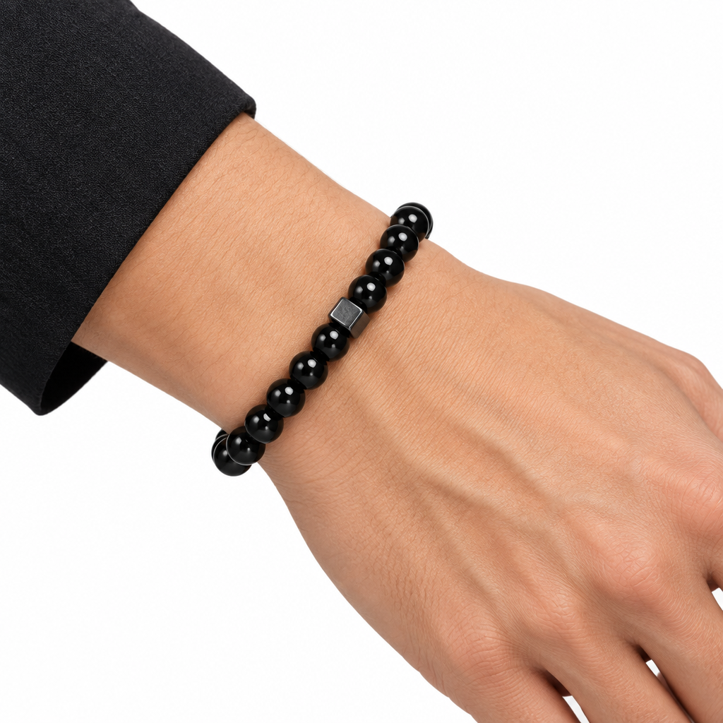 Bransoletka z czarnych koralików 8 mm z syntetycznego kamienia w stylu agatu na nadgarstku na białym tle