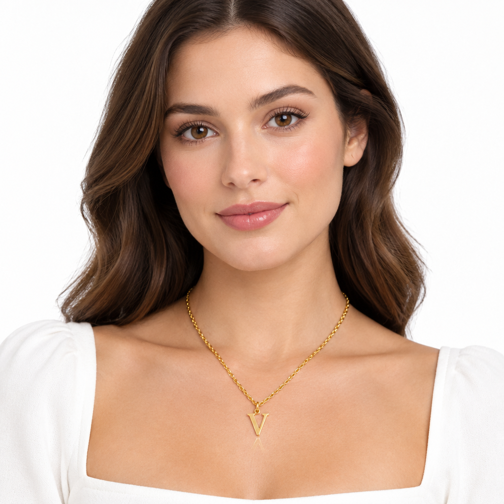 Modelka w złotym naszyjniku z literą V, na białym tle