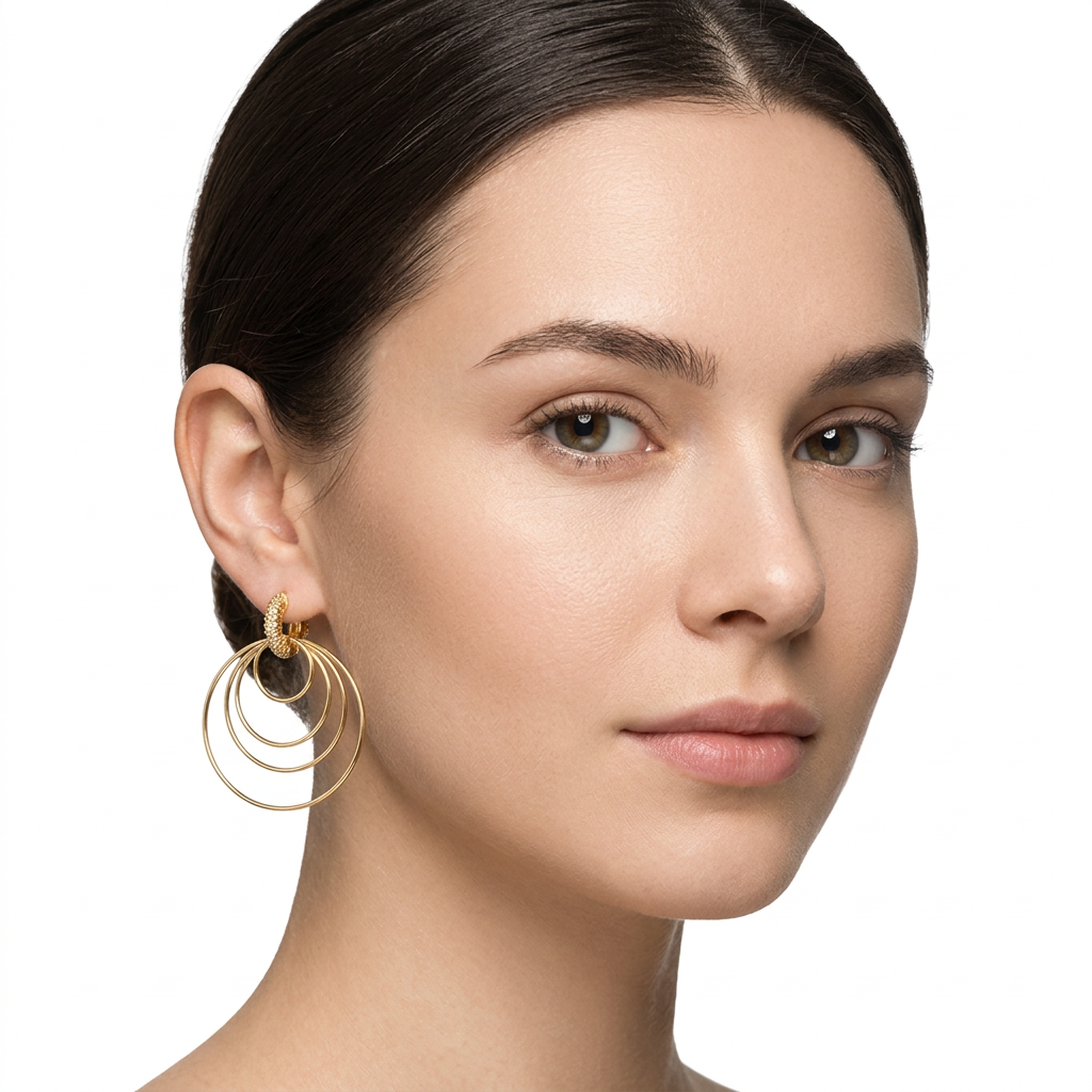 Modelka z kolczykiem z trzech cienkich obręczy w złotym kolorze na białym tle