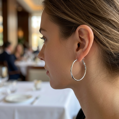 Srebrny cienki kolczyk kółko na modelce w restauracji
